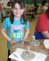 Student with tipi camp clay project